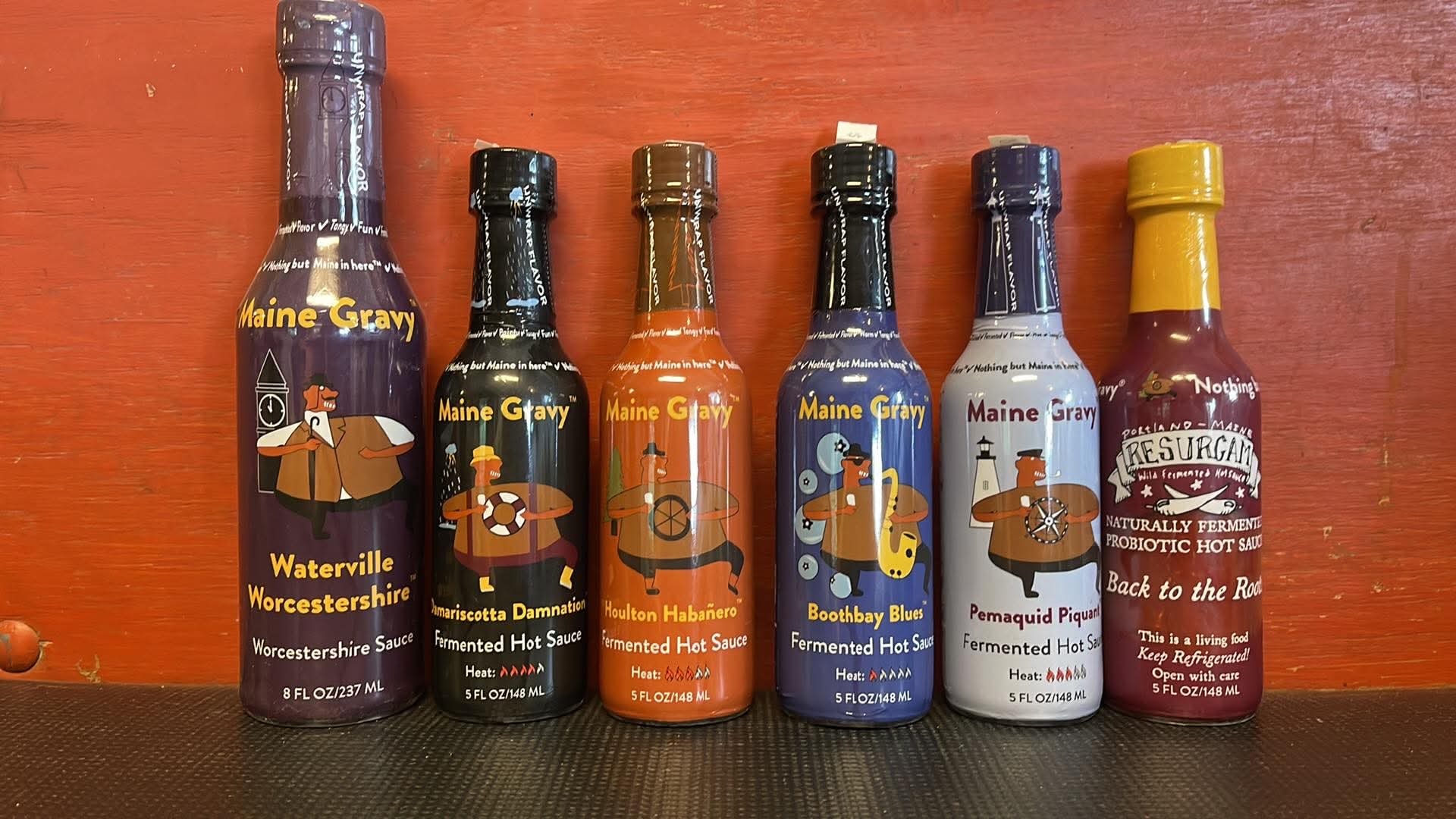 Maine Gravy sauce bottles including Waterville Worcestershire, Damariscotta Damnation, Houlton Habanero, Boothbay Blues, Pemaquid Piquant, and Back to the Roots hot sauces
