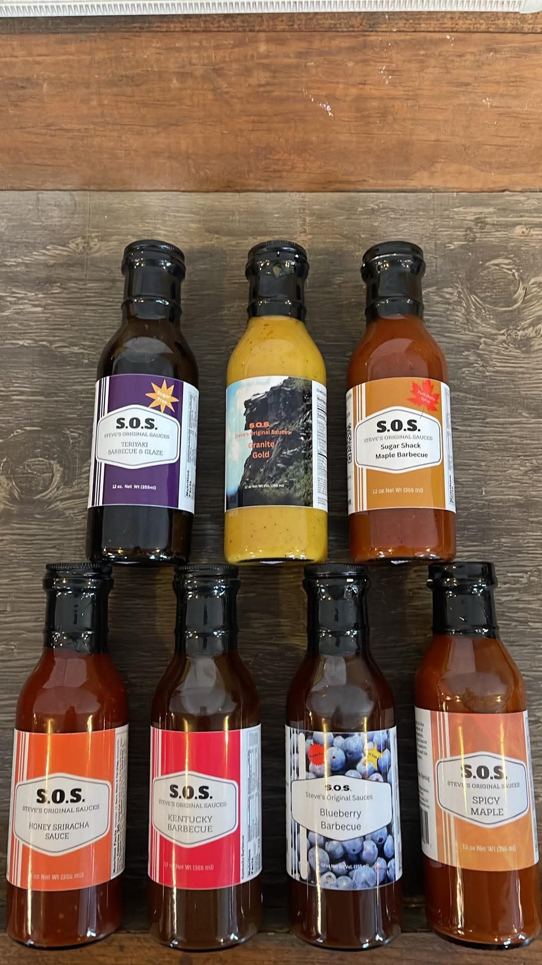 S.O.S. Steve's Original Sauces barbecue sauce bottles including Teriyaki, Granite Gold, Maple, Honey Sriracha, Kentucky, Blueberry, and Spicy Maple